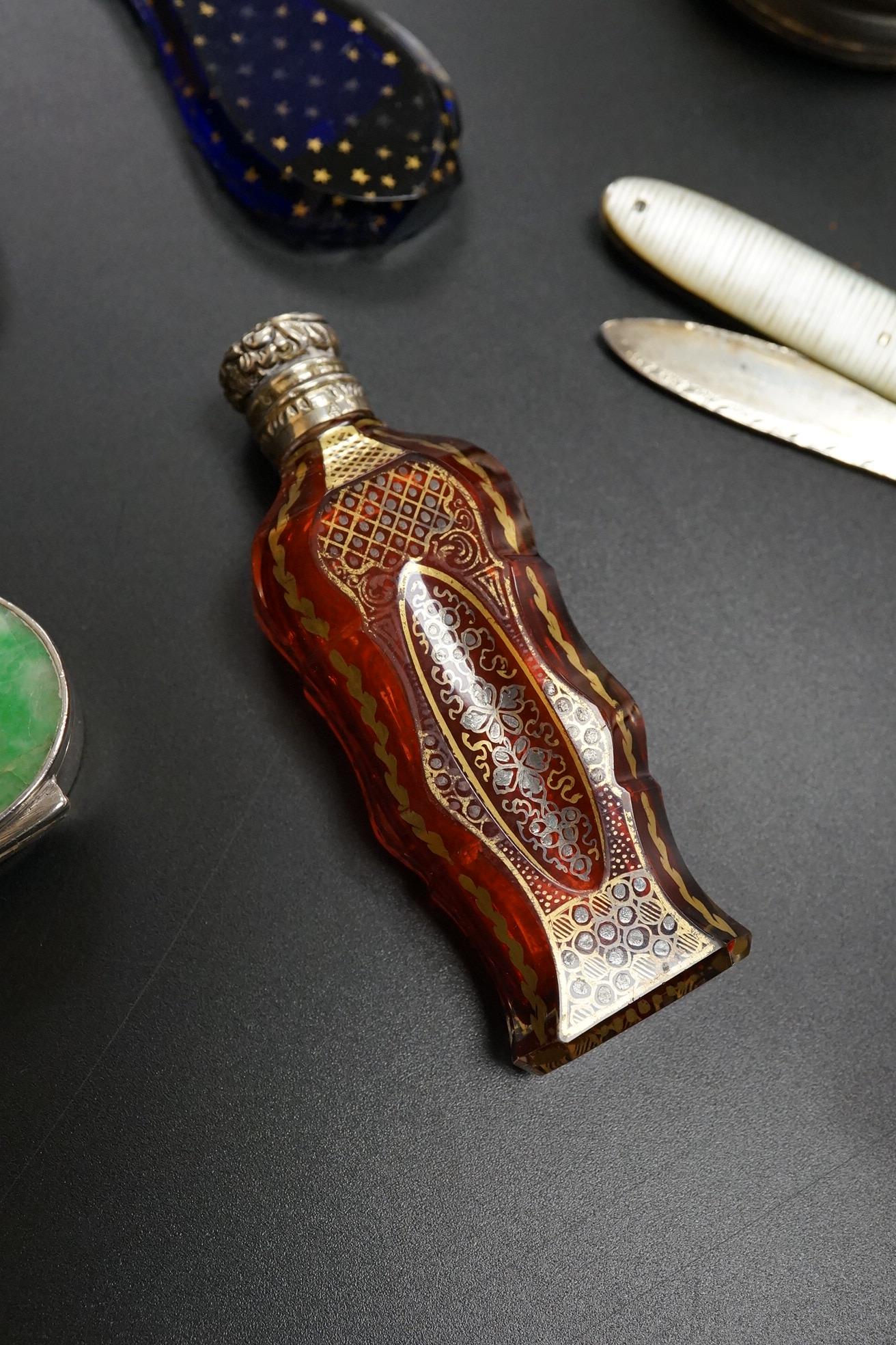 A collection of 19th century and later silver and white metal mounted items comprising three boxes, two glass scent bottles and a folding mother of pearl pen knife, largest 7.5cm high